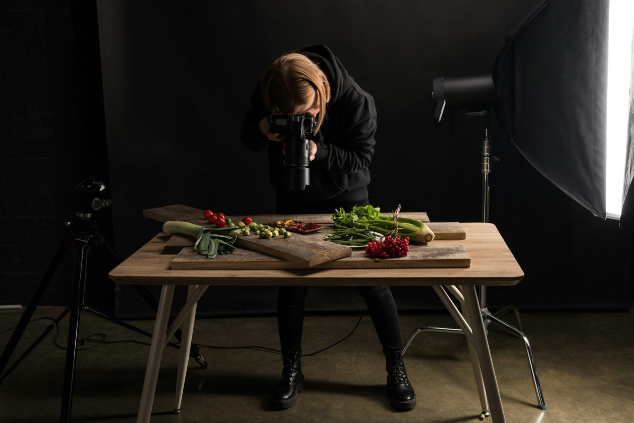 female photographer making food composition for commercial photography and taking photo on digital
